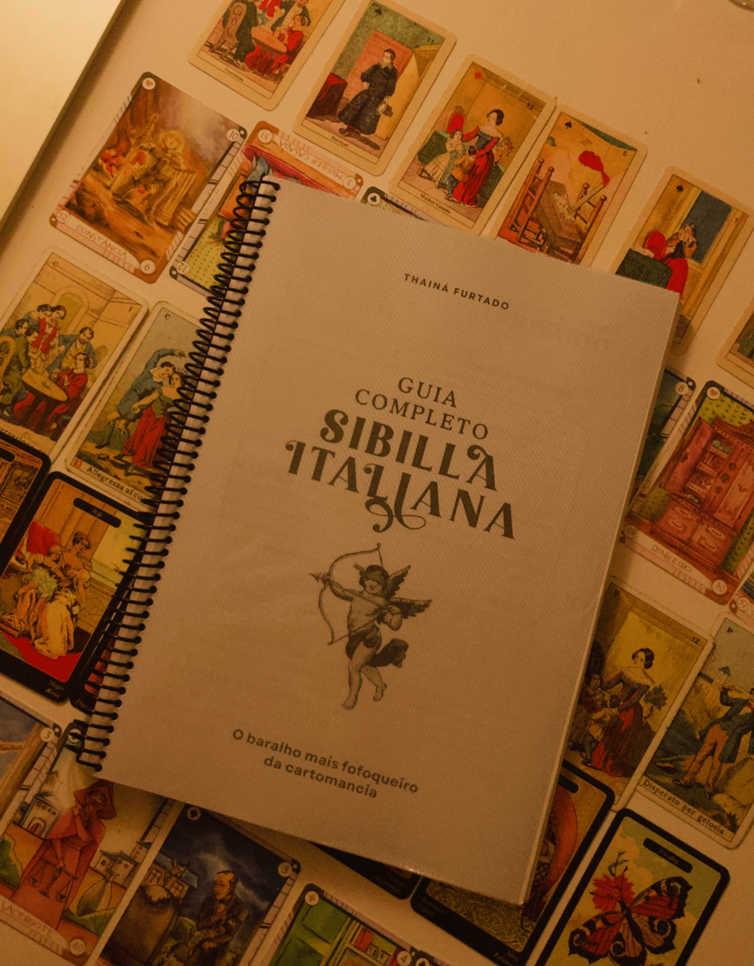 Guia Completo Sibilla Italiana de Thainá Furtado, encadernado em espiral sobre cartas do baralho